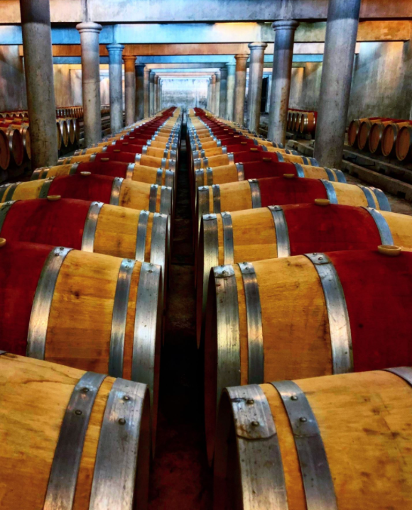 Chai Château Loudenne avec barriques empilées sur le sol